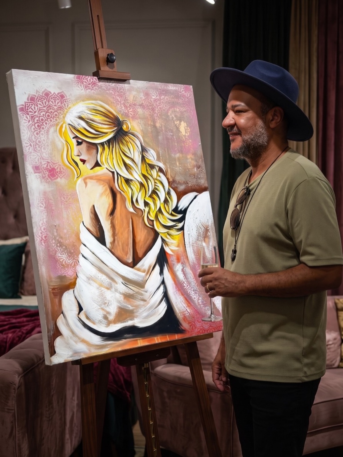 Orllando Rodríguez ao lado de uma tela na exposição do CENAP, em Cascavel